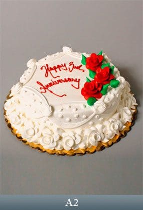 A white cake with red roses on top of it.