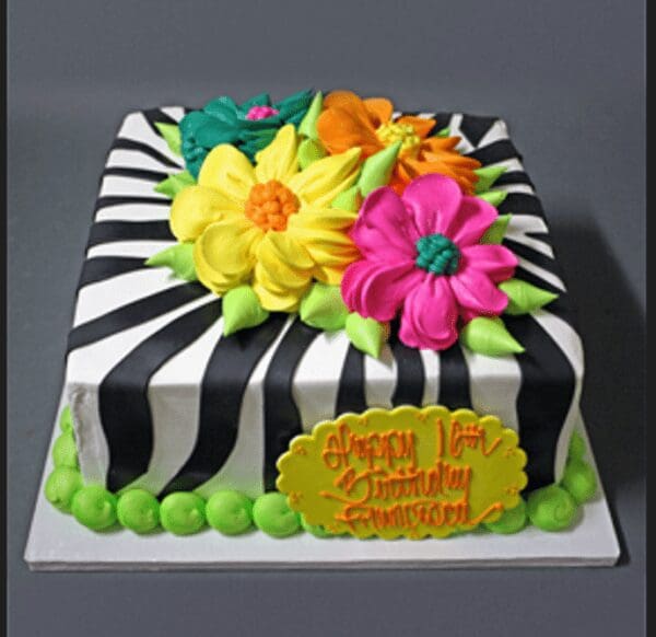 A square cake with zebra stripes and flowers.