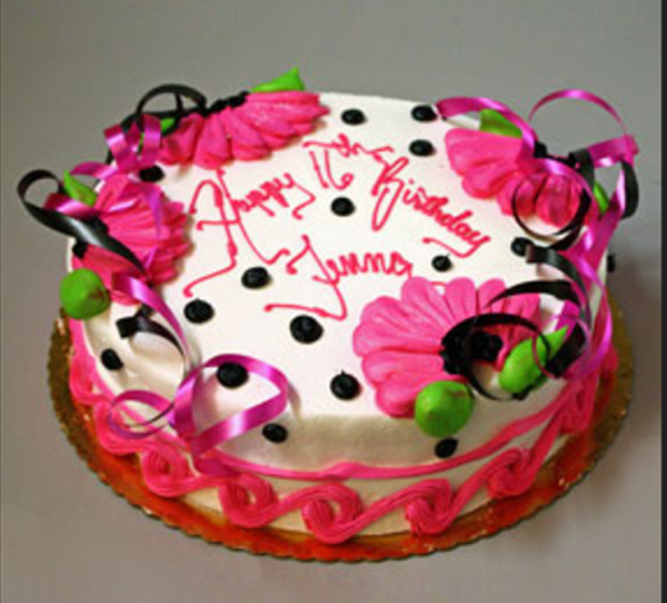 A birthday cake with pink and black polka dots.