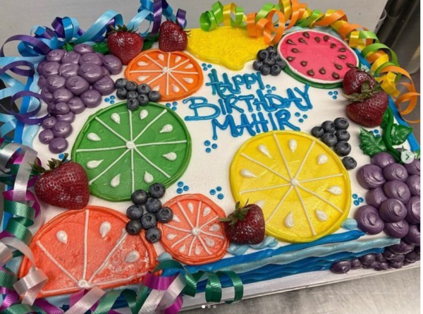 A birthday cake with fruit on it.