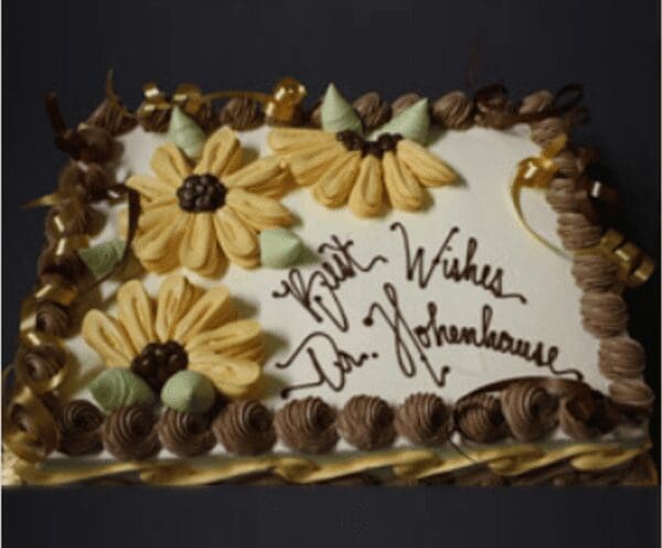 A cake with flowers and writing on it.