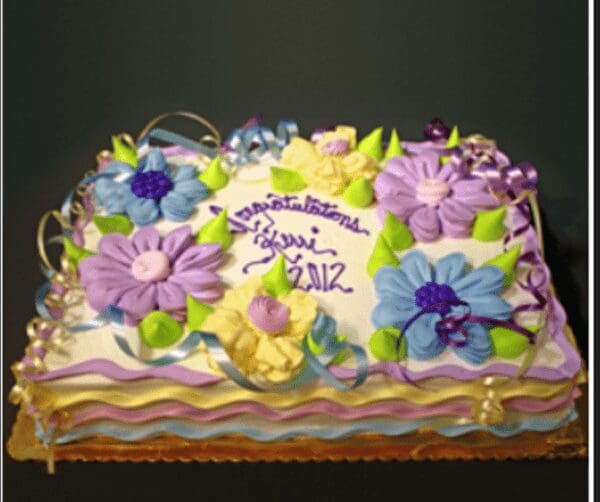 A cake with purple and yellow flowers on it.