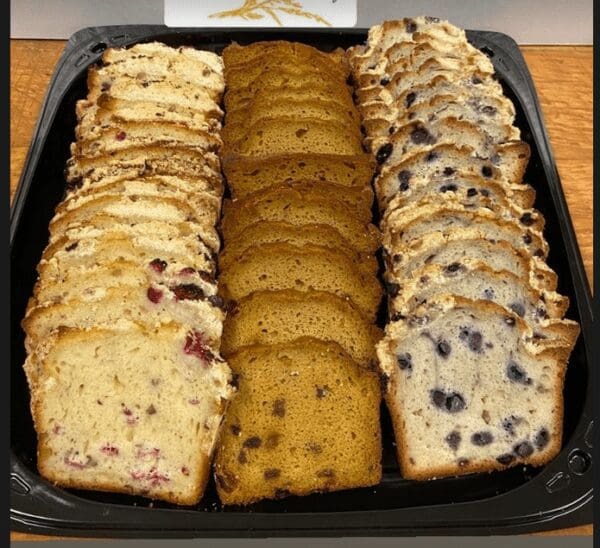 A tray of different kinds of bread on top of a table.